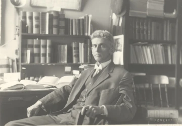 Dean Samuel Fegtly sitting in his office surrounded by books