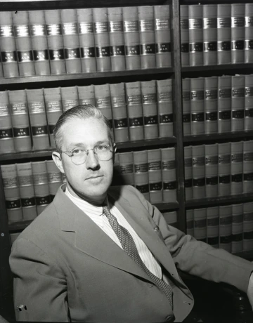 Lyons seated in front of books when he was city attorney.