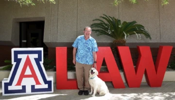Marc Miller with a dog in front of the University of Arizona College of Law.